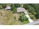 An aerial view of a home surrounded by lush trees, with a pool and extended parking spots at 4540 Park Ave, Indian Lake Estates, FL 33855