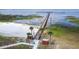 Picturesque beach area featuring a long wooden pier, palm trees, and convenient restroom facilities at 4540 Park Ave, Indian Lake Estates, FL 33855