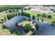 Aerial view of a lake with a bridge, surrounded by trees and a community building in the background at 4540 Park Ave, Indian Lake Estates, FL 33855