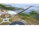 Scenic aerial view of a community area with a pier, recreational buildings, a pond with fountain, and flagpole at 4540 Park Ave, Indian Lake Estates, FL 33855