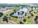 Scenic aerial view of a golf course with a lake, bridge, trees, and manicured greens at 4540 Park Ave, Indian Lake Estates, FL 33855