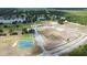 Panoramic aerial view of the tennis courts, golf course, lakes, and ample parking at 4540 Park Ave, Indian Lake Estates, FL 33855