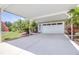 Covered two-car carport with a white garage door and an American flag, providing ample parking and shelter at 4540 Park Ave, Indian Lake Estates, FL 33855