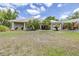Charming single-story home with a manicured lawn, beautiful landscaping, and a convenient covered carport at 4540 Park Ave, Indian Lake Estates, FL 33855