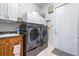 Functional laundry room with modern washer and dryer, ample cabinet space, and convenient access to the exterior at 4540 Park Ave, Indian Lake Estates, FL 33855