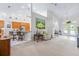 Open-concept living room with neutral color palette and view into kitchen with barstool seating at 4540 Park Ave, Indian Lake Estates, FL 33855