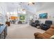 Open-concept living room with high ceilings, neutral carpet, and seamless flow to kitchen at 4540 Park Ave, Indian Lake Estates, FL 33855