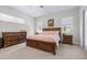 Inviting main bedroom with warm wood furniture, plush carpet, and ample natural light at 4540 Park Ave, Indian Lake Estates, FL 33855