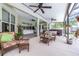 Spacious outdoor living area with comfortable seating, hot tub, ceiling fans, and direct access to the pool area at 4540 Park Ave, Indian Lake Estates, FL 33855