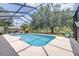 Enclosed pool with screen, featuring a clean, geometric design and a view of lush greenery at 4540 Park Ave, Indian Lake Estates, FL 33855