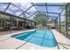 Screened-in pool with blue water and a spacious deck, adjacent to an outdoor living area at 4540 Park Ave, Indian Lake Estates, FL 33855