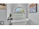 Relaxing bathroom showcases a classic soaking tub and arched window with natural light at 4965 Tradition Dr, Lakeland, FL 33812