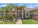 Inviting front entrance with brick pillars, lush landscaping, and a welcoming pathway leading to the front door at 4965 Tradition Dr, Lakeland, FL 33812