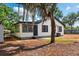 Charming single-story home with white siding, black trim, and inviting curb appeal enhanced by mature tree at 522 Channing Rd, Lakeland, FL 33805