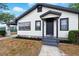 Inviting home with fresh landscaping, covered entry, and appealing white and dark gray color scheme at 522 Channing Rd, Lakeland, FL 33805