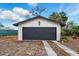 A detached garage featuring a gray garage door and white siding complemented by a concrete driveway at 522 Channing Rd, Lakeland, FL 33805
