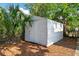 Outdoor storage shed with vertical siding, nestled among greenery in the backyard at 522 Channing Rd, Lakeland, FL 33805