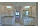 Hall bathroom with dual vanities, granite countertops, and wood-look tile flooring at 5220 Tennessee Ridge Ct, Auburndale, FL 33823