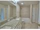 Bright bathroom features a granite vanity top and a shower-over-tub with decorative tiling at 5220 Tennessee Ridge Ct, Auburndale, FL 33823