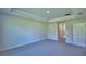 Cozy bedroom with plush carpeting, tray ceiling, and a window for natural light at 5220 Tennessee Ridge Ct, Auburndale, FL 33823