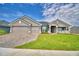 Beautiful single-Gathering home featuring a well-manicured lawn and a three-car garage with a brick paver driveway at 5220 Tennessee Ridge Ct, Auburndale, FL 33823