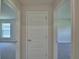 Hallway with two open rooms on either side of a central, closed door at 5220 Tennessee Ridge Ct, Auburndale, FL 33823
