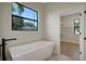 Bright and spacious bathroom featuring a modern soaking tub and a large window view at 5390 Clubhouse Hills Ln, Lakeland, FL 33812