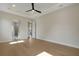 Bedroom with hardwood floors, tray ceiling, ceiling fan, and ensuite bath access at 5390 Clubhouse Hills Ln, Lakeland, FL 33812