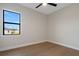 Bright bedroom with hardwood floors, ceiling fan, and a large window showcasing the outdoor view at 5390 Clubhouse Hills Ln, Lakeland, FL 33812