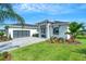 Well-maintained home with green lawn, mature palm trees, stylish driveway, and glass garage door at 5390 Clubhouse Hills Ln, Lakeland, FL 33812