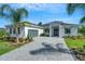 Beautiful single Gathering home with a modern design, a paved driveway, and mature landscaping at 5390 Clubhouse Hills Ln, Lakeland, FL 33812