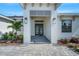 Elegant front entrance with a stylish door, stone walkway, manicured landscaping, and modern light fixtures at 5390 Clubhouse Hills Ln, Lakeland, FL 33812