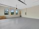 Spacious garage with three windows for natural light, neutral paint, and an epoxy floor at 5390 Clubhouse Hills Ln, Lakeland, FL 33812