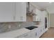 Detailed shot of the kitchen's white cabinets, stainless steel appliances, and herringbone backsplash at 5390 Clubhouse Hills Ln, Lakeland, FL 33812