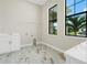 Bright laundry room with marble-look tile flooring, modern windows, and white cabinetry at 5390 Clubhouse Hills Ln, Lakeland, FL 33812