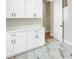Laundry room with white cabinets, marble-look tile floors, and a doorway at 5390 Clubhouse Hills Ln, Lakeland, FL 33812