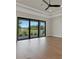 Open living room features wood-look floors and a large sliding glass door with backyard views at 5390 Clubhouse Hills Ln, Lakeland, FL 33812
