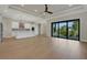 Open floorplan with hardwood flooring, white kitchen cabinets and stainless appliances, and a sliding glass door at 5390 Clubhouse Hills Ln, Lakeland, FL 33812
