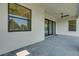 Covered patio featuring modern gray tile floors, ceiling fans, and sliding glass doors at 5390 Clubhouse Hills Ln, Lakeland, FL 33812