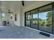 Covered patio features gray pavers, a ceiling fan, and an outdoor kitchen with a sink and mini refrigerator at 5390 Clubhouse Hills Ln, Lakeland, FL 33812