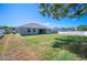 Wide shot of the home's backyard with a lush lawn, perimeter fence, and rear patio at 5531 Pebble Beach Dr, Lakeland, FL 33812
