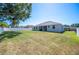 View of the home's backyard showing a spacious lawn, patio, and perimeter fencing at 5531 Pebble Beach Dr, Lakeland, FL 33812