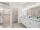 Bright bathroom featuring a walk-in shower, double vanity with granite countertops, and modern finishes at 5531 Pebble Beach Dr, Lakeland, FL 33812