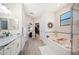 Bright bathroom featuring a soaking tub, walk-in shower, double vanity with granite countertops, and walk-in closet at 5531 Pebble Beach Dr, Lakeland, FL 33812