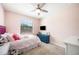 Bright pink bedroom with a plush bed, ceiling fan, large windows, and TV at 5531 Pebble Beach Dr, Lakeland, FL 33812