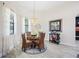 Cozy dining area featuring a modern chandelier, a glass table, and large bright windows at 5531 Pebble Beach Dr, Lakeland, FL 33812