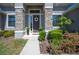 Close up of the front door with stone pillars, tasteful wreath and manicured shrubs at 5531 Pebble Beach Dr, Lakeland, FL 33812