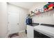 Laundry room with modern appliances, cabinets, and a door to the outside at 5531 Pebble Beach Dr, Lakeland, FL 33812
