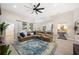 Open-concept living room with comfortable leather seating, ceiling fan, and view to kitchen and dining areas at 5531 Pebble Beach Dr, Lakeland, FL 33812
