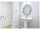 Charming powder room with a pedestal sink and decorative mirror at 6347 Ashley Dr, Lakeland, FL 33813
